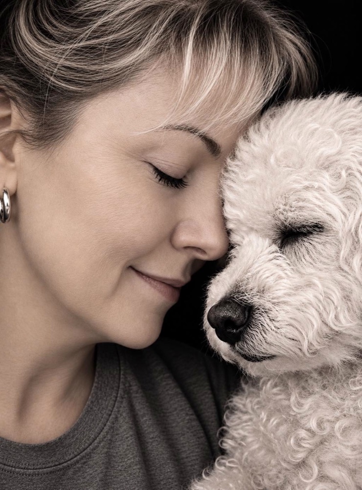 Sharie cheek to cheek with Clyde, her white Bichon mix